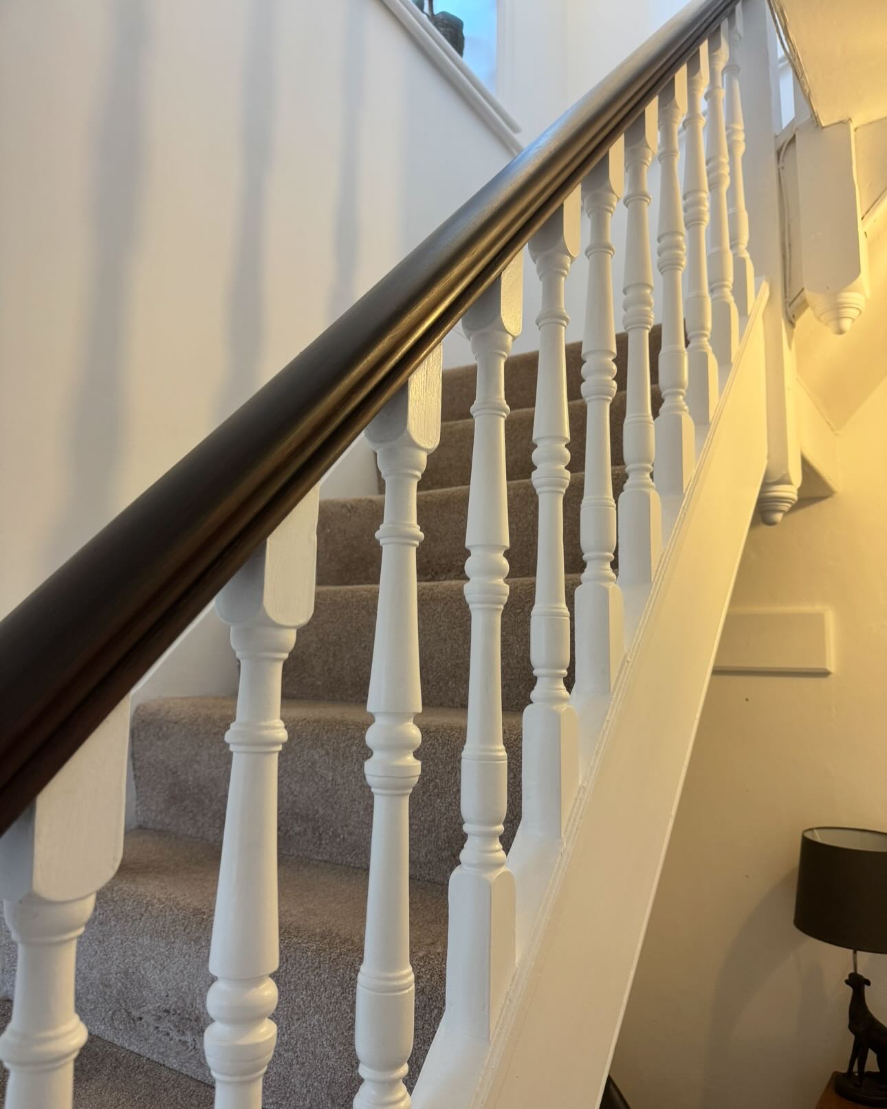 Freshly painted staircase with restored dark timber handrail
