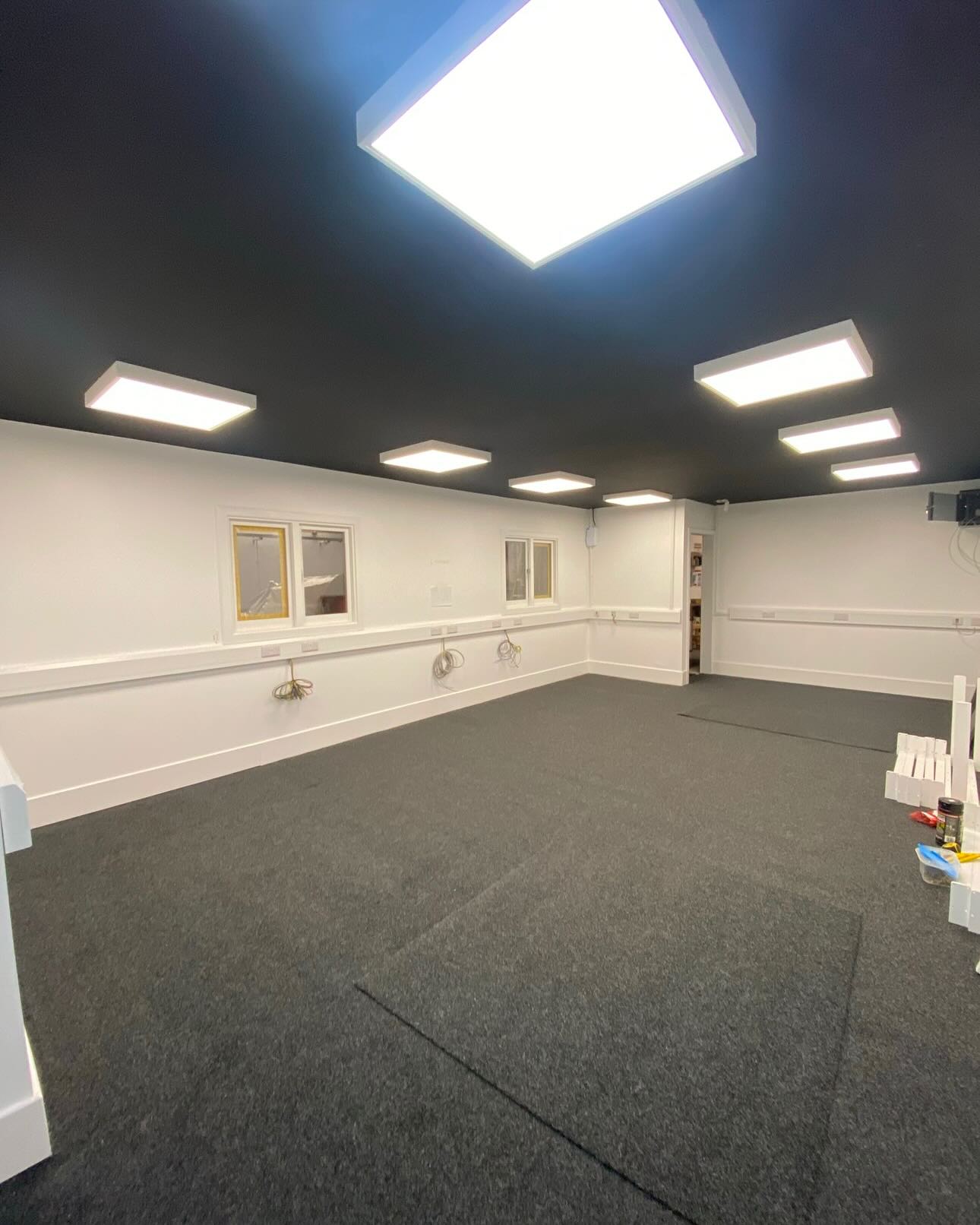 Completed office with dark ceiling and crisp white walls